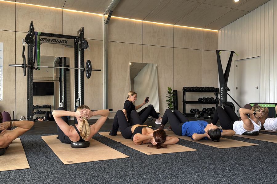A full class doing crunches on mats