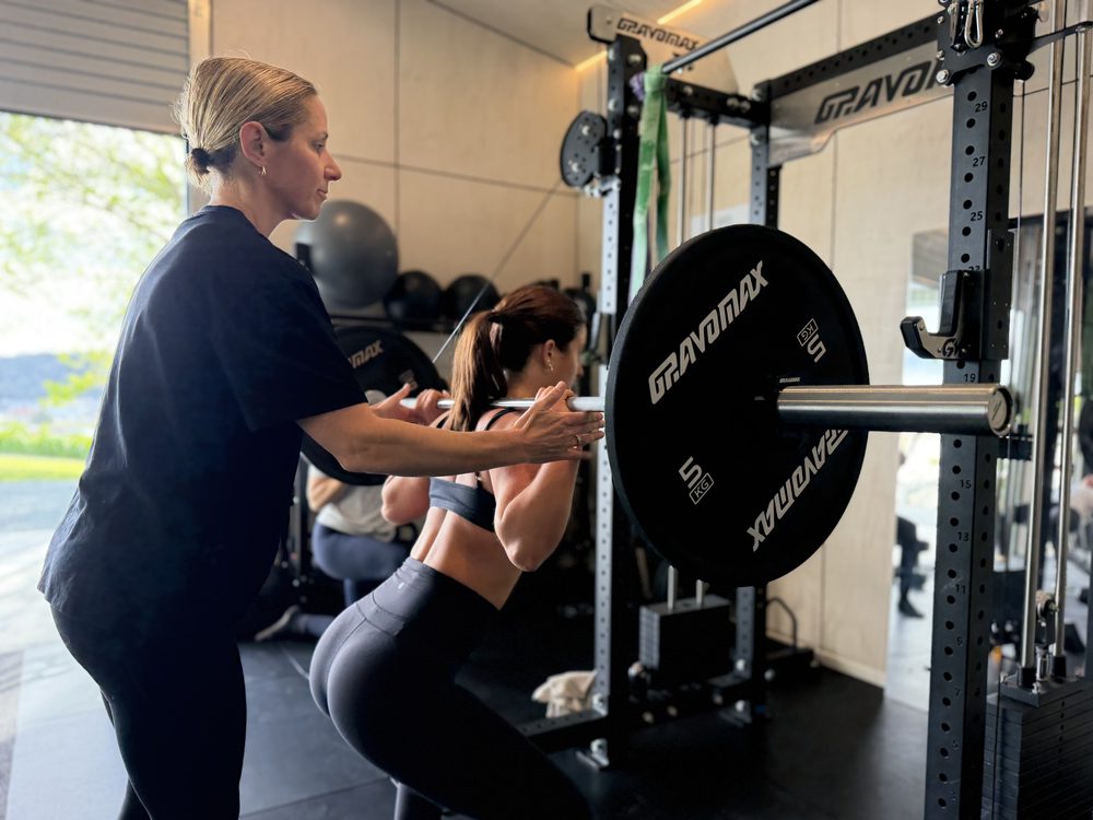 Kate coaching a barbell back squat at the rack